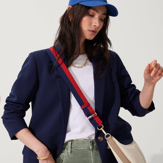 hover | The Crossbody Strap in Navy & Red, shown paired with The Crescent Bag, worn by a model, shown from the side