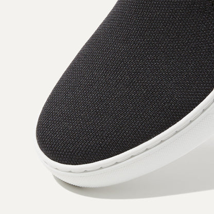 The slip-on Sneaker in Black Solid shown from the top view with detailing of the front of the shoe.