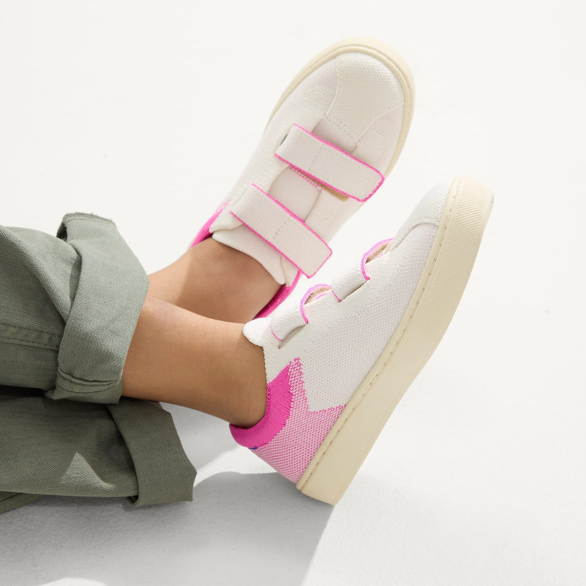 hover | A child modeling The Kids Strap Sneaker in Pink Taffy.