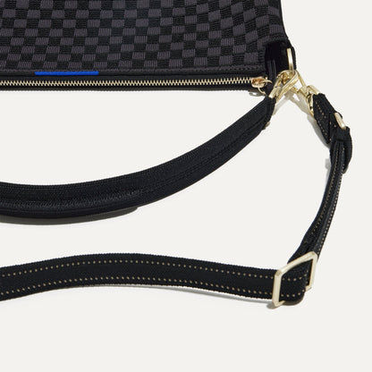 A closeup of The Daily Crossbody Bag in Black Sand, showing the smooth zipper closure and soft, flexible handle.