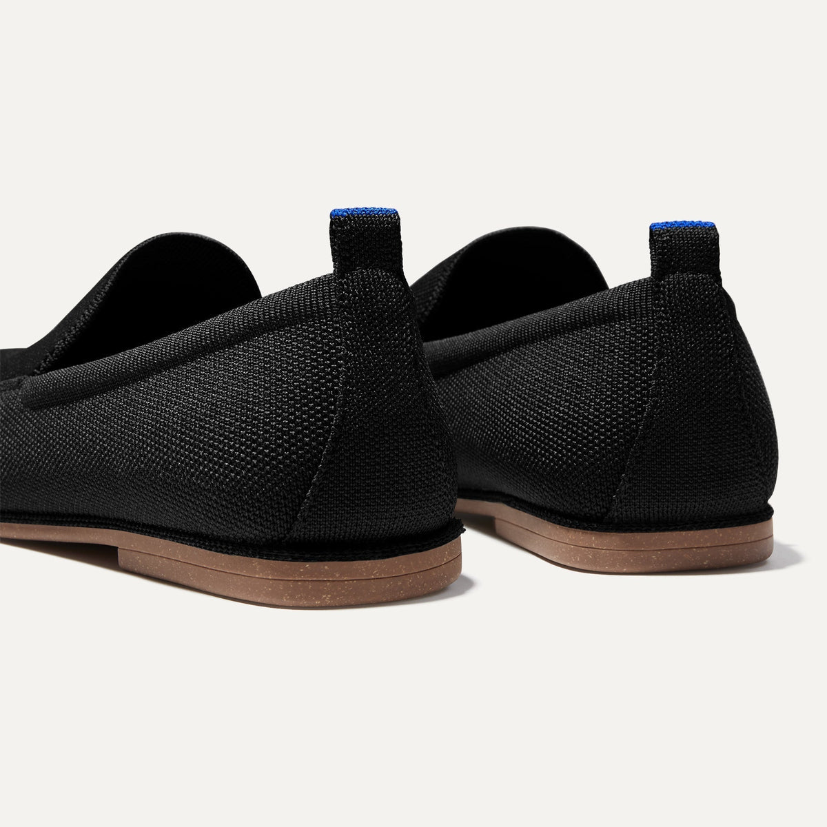 Close up of the heel of The Ravello Loafer in Stone Black, with Rothy's signature blue halo on the pull tab.