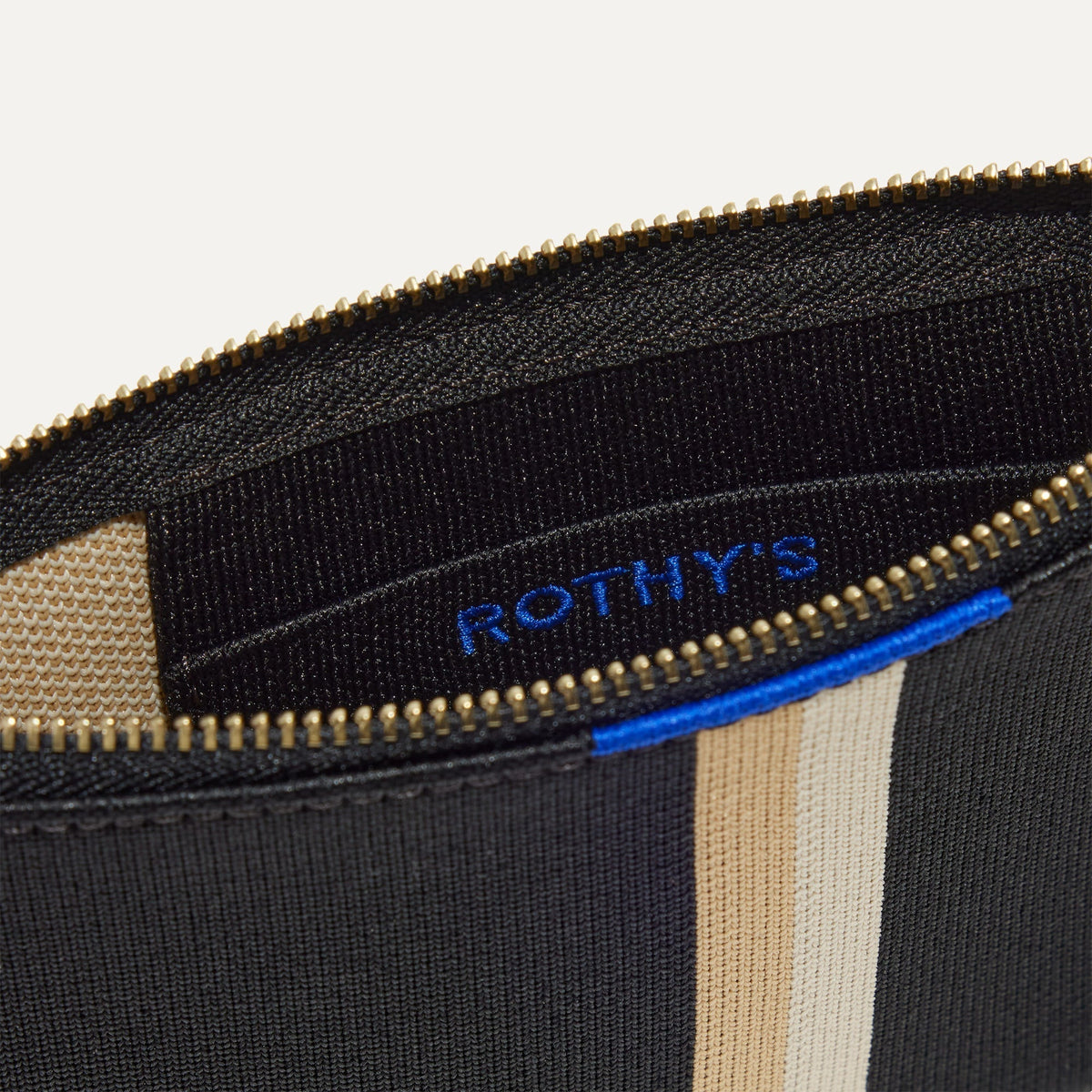 A closeup of The Wallet Wristlet in Black Portobello Stripe, focusing on the inner card slip.