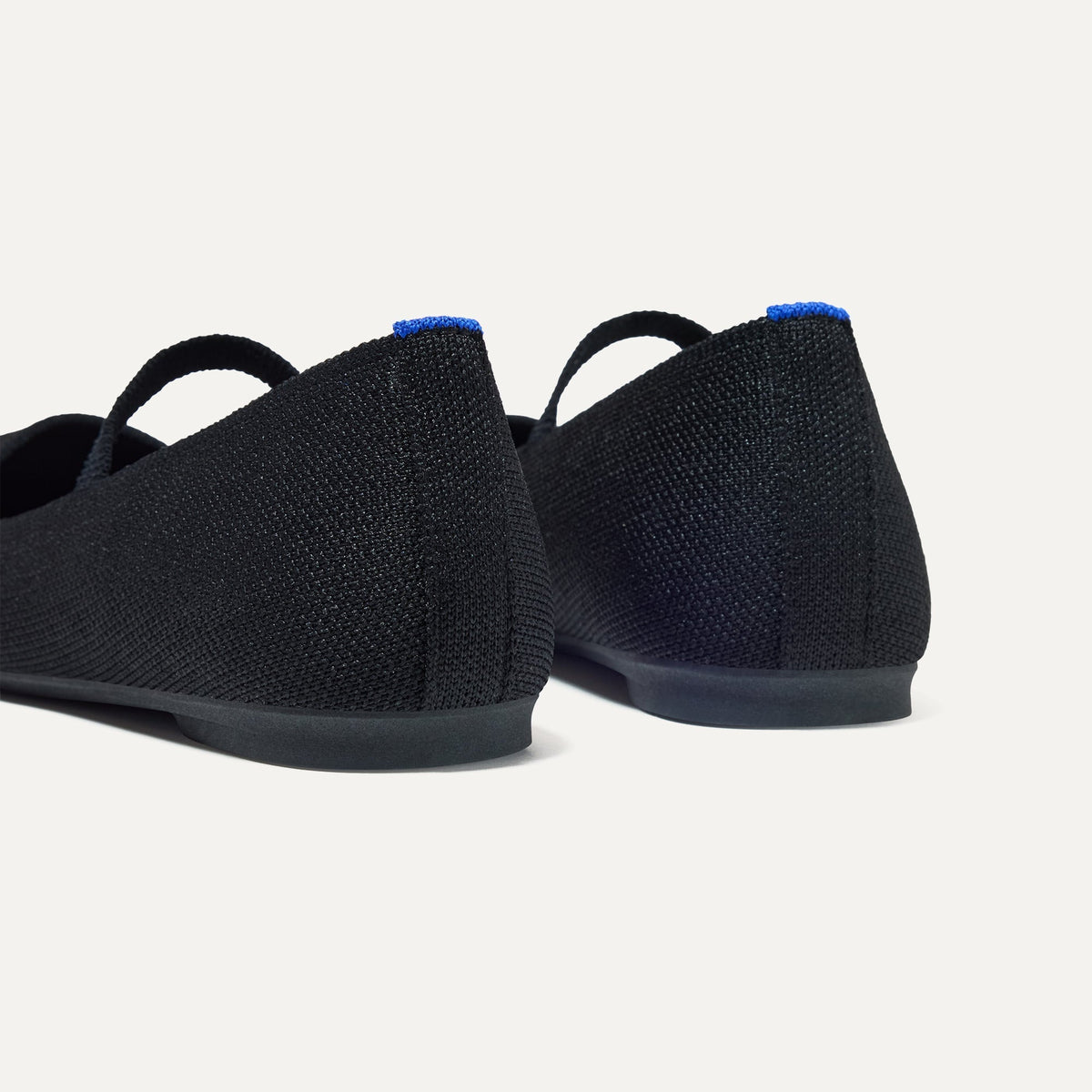 Close up of the heel of The Max Square Mary Jane in Black, with Rothy's signature blue halo.