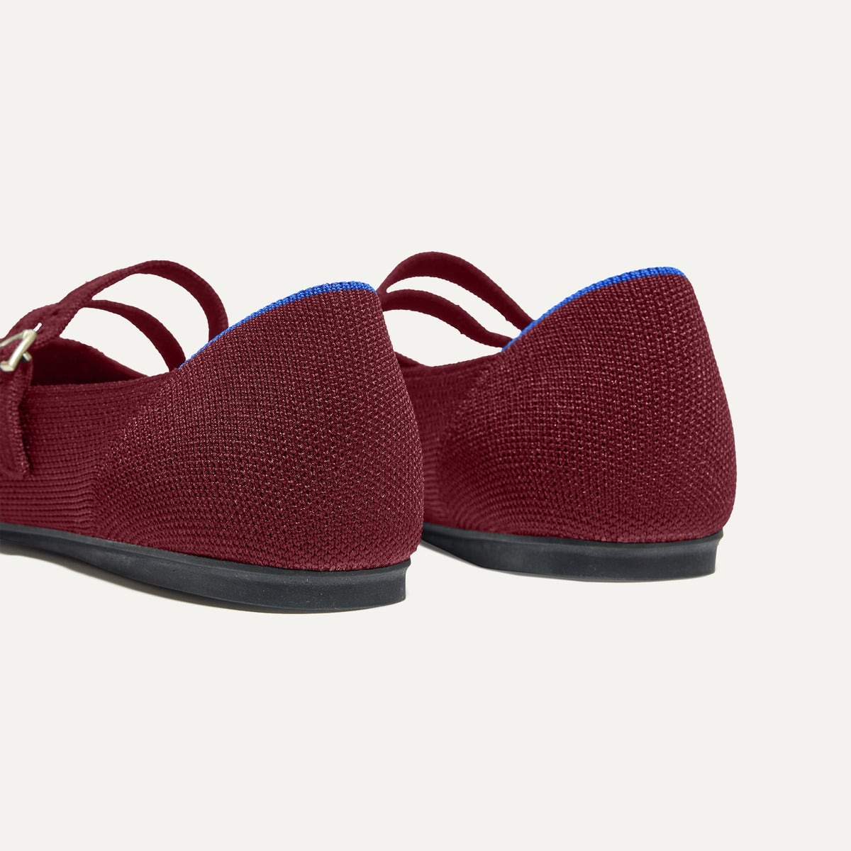 Close up of the heel of The Double Buckle Mary Jane in Cabernet, with Rothy's signature blue halo.