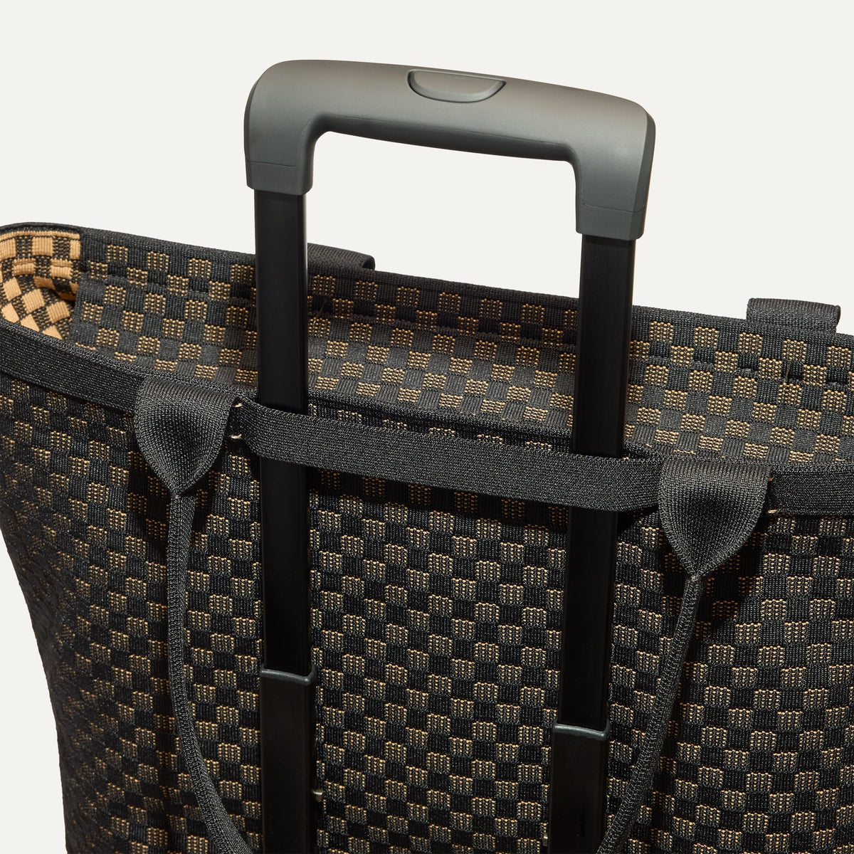 The Zip Travel Tote shown attached to a rolling suitcase using the wrap-around band.