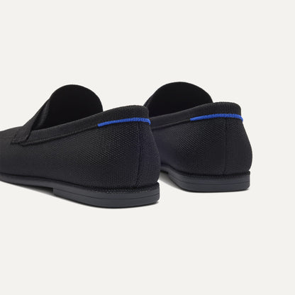 Close up of the heel of The Ravello Penny Loafer in Black, with Rothy's signature blue halo on the pull tab.